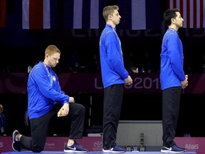 Gold medalist Race Imboden of the U.S. takes a knee during the National Anthem Ceremony on the podium for the Fencing Men's Foil Team Gold Medal on Day 14 of Lima 2019 Pan American Games at the Lima Convention Center in Lima, Peru, on Friday, Aug. 9, 2019.