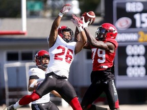 Calgary Stampeders Team Red Richard Sindani makes a nice catch with defender Team White Dagogo Maxwell on him during the Red and White game at McMahon stadium in Calgary on Sunday May 27, 2018. Darren Makowichuk/Postmedia