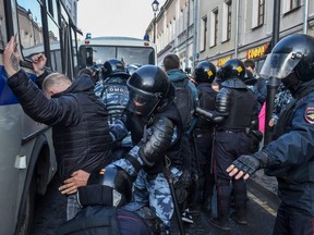 Servicemen of the Russian National Guard detain a man and conduct searches after a rally urging fair elections in Moscow on Saturday, Aug. 10, 2019.