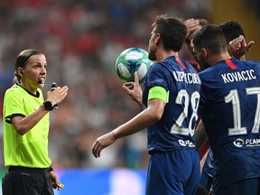 French referee Stephanie Frappart (left) speaks with Chelsea players during the UEFA Super Cup match between Liverpool and Chelsea at Besiktas Park Stadium in Istanbul on August 14, 2019. (BULENT KILIC/AFP/Getty Images)