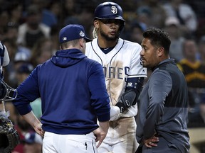 Padres manager Andy Green and a trainer talk with Fernando Tatis Jr. at Petco Park August 13, 2019 in San Diego. (Denis Poroy/Getty Images)