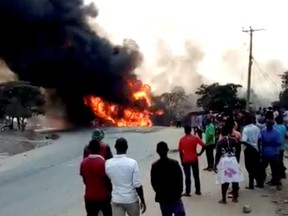 People look towards a fire following a fuel truck collision in Rubirizi, Uganda August 18, 2019 in this still image taken from social media video.