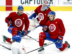 Ryan Poehling, left, goalie Cayden Primeau and Nick Suzuki follow Jake Evans's lead during stretching at Canadiens rookie camp workout at the Bell Sports Complex in Brossard on Thursday.