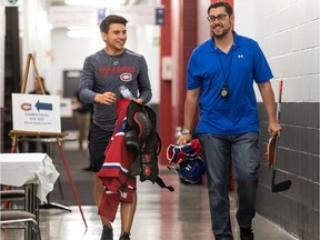 Canadiens prospect Nick Suzuki and Charles Demers of the Canadiens' marketing department walk together at the Bell Sports Complex in Brossard on the first day of training camp on Sept. 12, 2019.