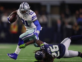 Ezekiel Elliott, left, of the Dallas Cowboys breaks a tackle attempt by Shaquill Griffin of the Seattle Seahawks in the fourth quarter during the Wild Card Round at AT&T Stadium on Jan. 5, 2019 in Arlington, Texas.