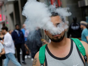 A man uses a vape as he walks on Broadway in New York City, Sept. 9, 2019. REUTERS/Andrew Kelly/File Photo