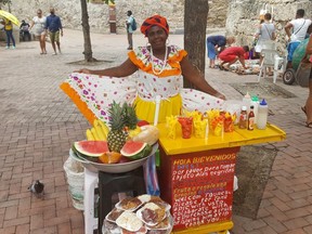 A colourfully dressed palenqueras at her fruit stand inside Cartagena's historic walled city. (Dave Hilson)