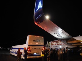 Members of the media inspect the wing from Liberal Leader Justin Trudeau's campaign plane after being struck by the media bus following landing in Victoria, B.C., on Wednesday, Sept.11, 2019. THE CANADIAN PRESS/Sean Kilpatrick