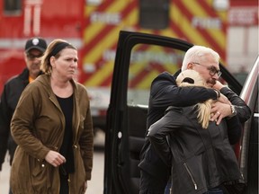 People hug as Edmonton Fire Rescue Services investigators and Edmonton Police Service officers are on scene of a fatal house fire in Edmonton, on Wednesday, Sept. 18, 2019.