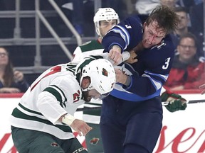 Jets defenseman Tucker Poolman (3) and Minnesota Wild left wing Mike Liambas (27) fight on Wednesday night. at Bell MTS Place. James Carey Lauder-USA TODAY Sports