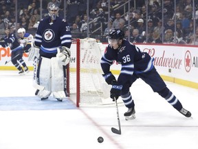 Winnipeg Jets defenceman Ville Heinola skates past Winnipeg Jets goaltender Connor Hellebuyck in the first period against the St. Louis Blues at Bell MTS Place on Friday. Heinola, the team's first-round pick (20th overall) back in June, hasn't looked out of place among men.