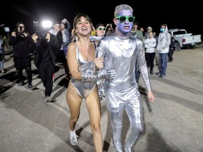 People dressed in costumes chant as they approach a gate to Area 51 as an influx of tourists responding to a call to 'storm' Area 51.