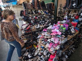 In this file photo taken on August 24, 2019 a woman shops for Chinese made shoes at a store in the Chinatown area of Los Angeles, California. - Washington is moving ahead on September 1, 2019, with new tariffs on Chinese imports as it steps up a high-pressure campaign aimed at coercing Beijing to sign a new trade deal even amid fears of a further slowing of US and world growth. The additional 15 percent tariffs, affecting a portion of the $300 billion in goods from the Asian giant that so far has been spared, will take effect at 04H01 GMT, according to the US Trade Representative's office.