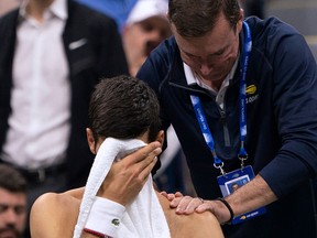Novak Djokovic of Serbia has his shoulder worked on by a trainer while playing Stan Wawrinka of Switzerland during their Round Four Men's Singles match at the 2019 US Open at the USTA Billie Jean King National Tennis Center in New York on September 1, 2019. (Don Emmert / Getty Images)