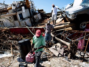 People recover items from a beached boat after Hurricane Dorian September 5, 2019, in Marsh Harbor, Great Abaco. Hurricane Dorian lashed the Carolinas with driving rain and fierce winds as it neared the US east coast Thursday after devastating the Bahamas and killing at least 20 people. (Brendan Smialowski / Getty Images)