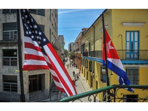 This file photo taken on March 17, 2016 shows Cuban and US flags in Havana. Cuba's state news agency Prensa Latina officially restarted journalism operations in the US capital of Washington on April 28, 2017, unfreezing 50 years of inactivity and marking another step in the rapprochement between America and the Communist island.