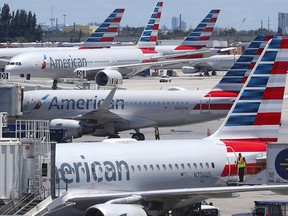 In this April 24, 2019, photo, American Airlines aircraft are shown parked at their gates at Miami International Airport in Miami. (AP Photo/Wilfredo Lee, File)