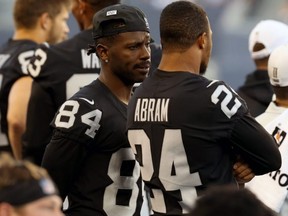 Raiders wide receiver Antonio Brown (84) speaks with teammate Jonathan Abram (24) on the sideline during NFL exhibition action against the Packers at IG Field in Winnipeg on  Aug. 22, 2019.