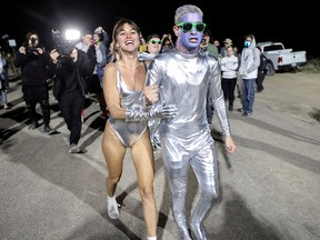 People dressed in costumes chant as they approach a gate to Area 51, a secretive U.S. military base believed by UFO enthusiasts to hold government secrets about extra-terrestrials in Rachel, Nev., Sept. 20, 2019.