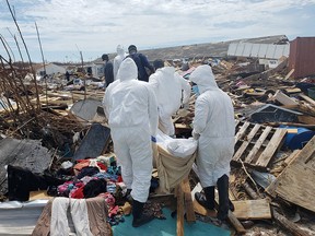 Members of the Bahamian Defence Force remove bodies from the destroyed Abaco shantytown called Pigeon Peas, after Hurricane Dorian in Marsh Harbour, Bahamas September 8, 2019. (REUTERS/Zach Fagenson)