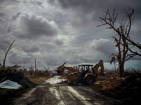 Mos Antenor, 42, drives a bulldozer while clearing the road after Hurricane Dorian Mclean's Town, Grand Bahama, Bahamas, Friday Sept. 13, 2019.