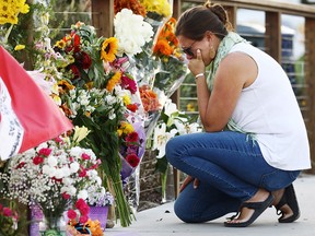 A woman looks emotional as she kneels at a makeshift memorial in Santa Barbara Harbor for victims of the Conception boat fire on September 3, 2019 in Santa Barbara, California. (Mario Tama/Getty Images)