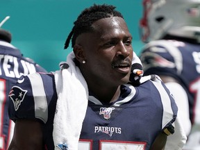 Antonio Brown watches from the sidelines in the second half of the New England Patriots game against the Miami Dolphins at Hard Rock Stadium in Miami.