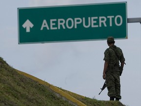 A soldier stands guard next to Cancun´s airport entrance in Riviera Maya, near Cancun, Mexico, Sunday, Feb. 21, 2010. (AP Photo/Israel Leal)