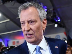 In this file photo taken on July 31, 2019, Mayor of New York City Bill de Blasio makes his way through the spin room after the second round of the second Democratic primary debate of the 2020 presidential campaign season hosted by CNN at the Fox Theatre in Detroit, Mich.