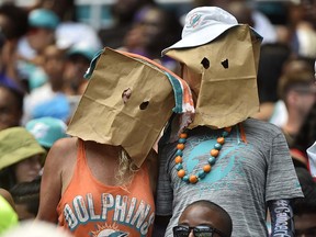 Two Miami Dolphins fans wear bags on their heads during game against the Baltimore Ravens at Hard Rock Stadium on September 8, 2019 in Miami. (Eric Espada/Getty Images)