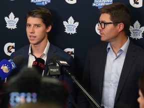 Maple Leafs winger Mitch Marner (left) and general manager Kyle Dubas are surrounded by media during a press conference at the Paradise Double Ice Complex in Paradise, NL on Saturday. Marner and the Maple Leafs have agreed on a new contract after a long off-season negotiation. (Paul Daly/The Canadian Press)