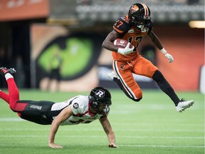 B.C. Lions' Ryan Lankford, right, leaps to avoid a tackle by Ottawa Redblacks kicker Richie Leone while returning a punt during the first half of a CFL football game in Vancouver, on Friday Sept. 13, 2019.