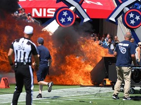 Crews work to put out a fire on the field from pregame pyrotechnics before a game between the Tennessee Titans and Indianapolis Colts at Nissan Stadium.