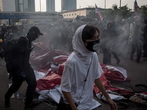 Pro-democracy protesters stand around and set fire too a banner promoting China's 70th anniversary  on September 15, 2019 in Hong Kong, China.