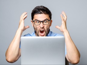 Portrait of amazed man with laptop computer over gray background
