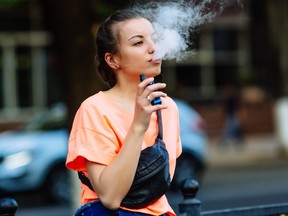 A young woman smokes an e-cigarette. (Getty Images file photo)