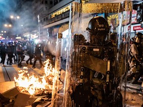Riot police walk past a barricade set on fire by protesters after dispersing crowds outside the Mongkok Police Station on September 7, 2019 in Hong Kong, China. (Anthony Kwan/Getty Images)