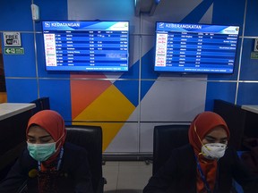 Airline staff wear masks as they check in passengers at the Sultan Syarif Kasim II airport in Pekanbaru on September 16, 2019. (WAHYUDI/AFP/Getty Images)