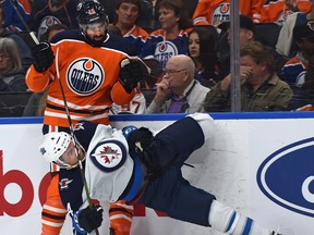 Edmonton Oilers Jujhar Khaira hits Winnipeg Jets Neal Pionk during pre-season action last night. (Ed Kaiser/Postmedia)