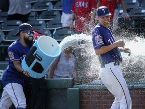 Texas Rangers second baseman Rougned Odor (12) gives Texas Rangers starting pitcher Mike Minor (23) a cold shower after the game against the Boston Red Sox at Globe Life Park in Arlington. (Kevin Jairaj-USA TODAY Sports)