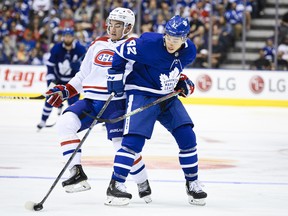 Habs’ Nick Suzuki (left) gets tangled up with Maple Leafs’ Trevor Moore during Wednesday’s pre-season game in Toronto. (THE CANADIAN PRESS)