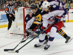 Columbus Blue Jackets' Kevin Stenlund gets the puck away from Pittsburgh Penguins' Sam Poulin in the second period of a preseason NHL hockey game Thursday, Sept. 19, 2019, in Pittsburgh.