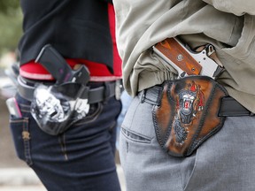 Art and Diana Ramirez of Austin with their pistols in custom-made holsters during an open carry rally at the Texas State Capitol on January 1, 2016 in Austin, Texas. (Erich Schlegel/Getty Images)