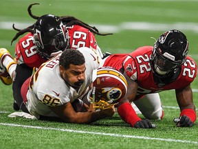 Washington Redskins tight end Jordan Reed loses his helmet as he is hit by Atlanta Falcons strong safety Keanu Neal during the first half at Mercedes-Benz Stadium.