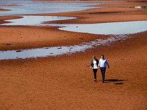 Conservative Leader Andrew Scheer and his wife Jill walk on the beach after making a campaign stop in Canoe Cove, P.E.I., on Sunday, Sept. 22, 2019.