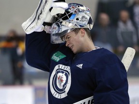 Eric Comrie puts his mask back on during Winnipeg Jets practice at Bell MTS Iceplex on April 8, 2019.