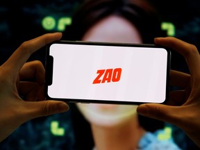 The logo of the Chinese app ZAO, which allows users to swap their faces with celebrities and anyone else, is seen on a mobile phone screen in front of an advertisement of the app, in this illustration picture taken September 2, 2019. REUTERS/Florence Lo/Illustration