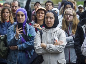 Nada Nour, with her son Omar, and others listen to a speaker at a rally that teachers organized against Bill 21 in Montreal Saturday, Sept. 28, 2019 outside the Parc metro station.