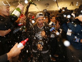 Gleyber Torres #25 of the New York Yankees celebrates with teammates in the locker room after sweeping the Minnesota Twins 3-0 in the American League Division Series to advance to the American League Championship Series at Target Field on October 07, 2019 in Minneapolis, Minnesota. (Photo by Elsa/Getty Images)