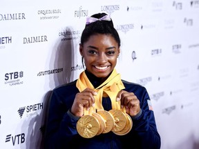 Simone Biles of The United States poses for photos with her multiple gold medals during day 10 of the 49th FIG Artistic Gymnastics World Championships at Hanns-Martin-Schleyer-Halle on October 13, 2019 in Stuttgart, Germany.